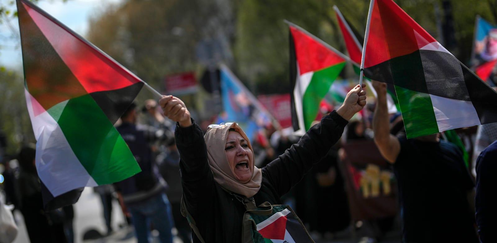 מפגינה באיסטנבול מניפה דגלי פלסטין בהפגנה למען עזה. בציבור הטורקי גוברות הקריאות לניתוק הקשרים הכלכליים עם ישראל / צילום: ap, Khalil Hamra מפגינה באיסטנבול מניפה דגלי פלסטין בהפגנה למען עזה. בציבור הטורקי גוברות הקריאות לניתוק הקשרים הכלכליים עם ישראל / צילום: ap, Khalil Hamra