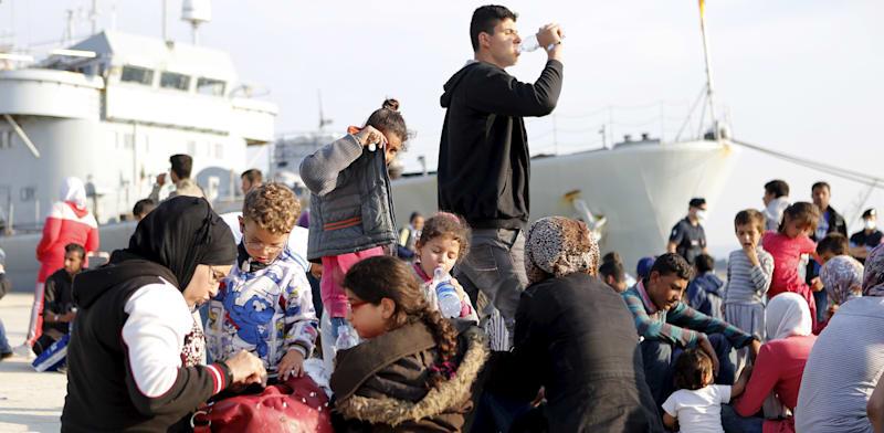 פליטים סורים יורדים מספינה בלגית בנמל באיטליה / צילום: Reuters, Antonio Parrinello פליטים סורים יורדים מספינה בלגית בנמל באיטליה / צילום: Reuters, Antonio Parrinello