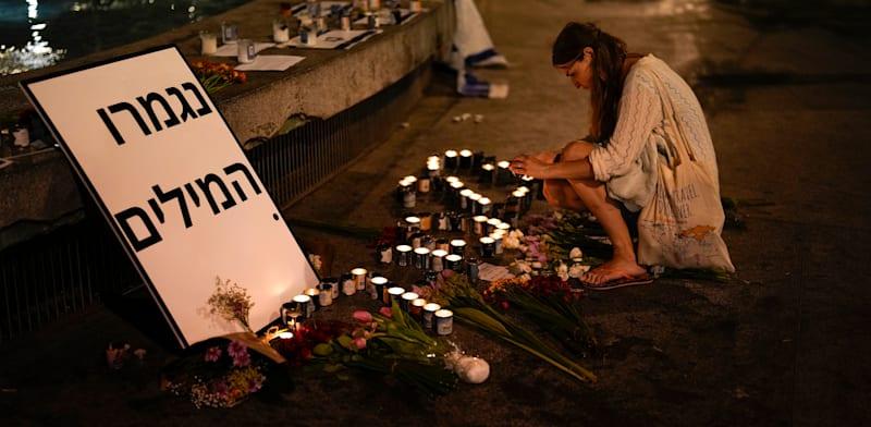 אישה מדליקה נרות נשמה בכיכר דיזנגוף בתל אביב, 13 באוקטובר 2023 / צילום: ap, Francisco Seco אישה מדליקה נרות נשמה בכיכר דיזנגוף בתל אביב, 13 באוקטובר 2023 / צילום: ap, Francisco Seco