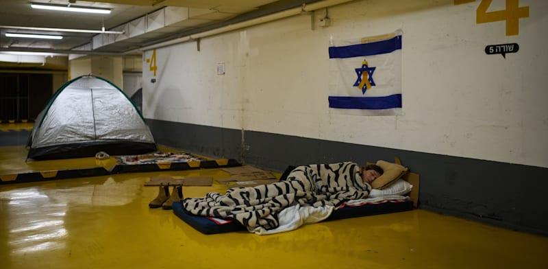 אישה ישנה בחניון תת-קרקעי בתל אביב / צילום: ap, Oded Balilty אישה ישנה בחניון תת-קרקעי בתל אביב / צילום: ap, Oded Balilty